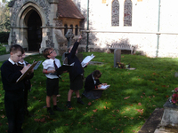 year 3 pupils from Hopton C of E Primary School pointing up at Hopton war memorial, Norfolk while carrying out condition survey © War Memorials Trust, 2018